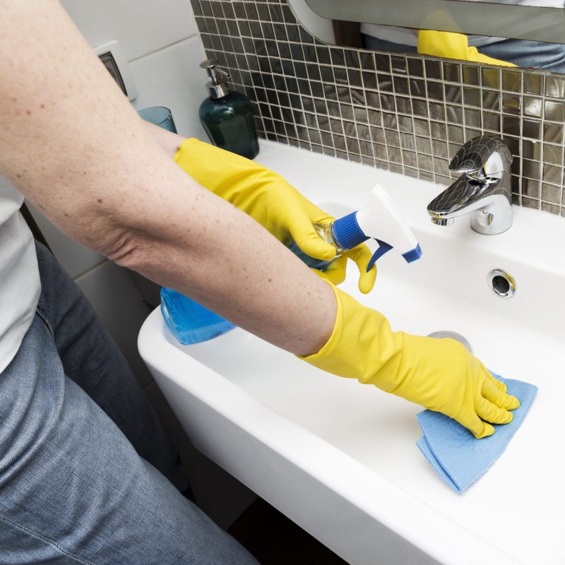 woman-with-rubber-gloves-cleaning-sink